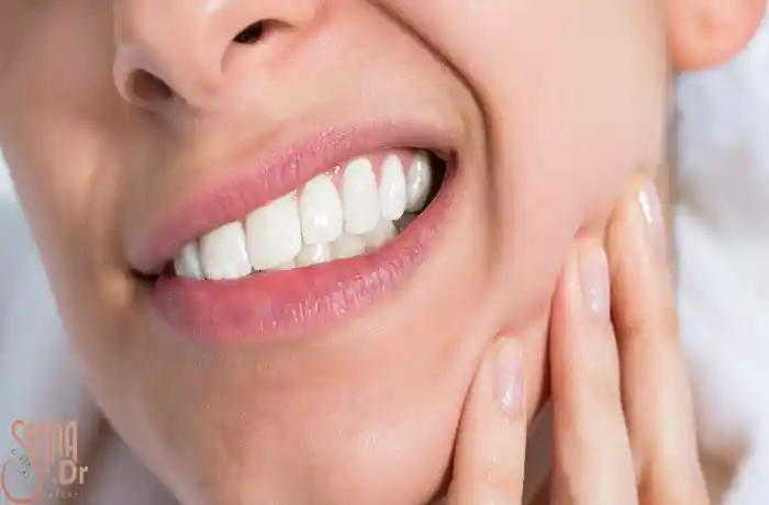 علت حساس شدن دندان، دندان های یک خانم